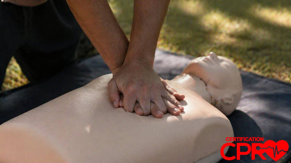 Person performing hands-only CPR on a mannequin outdoors in Tallahassee.